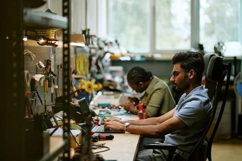 Indian Man Working on Laptop in Electronics Workshop 스톡 사진