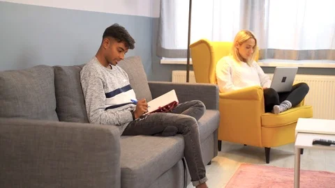 Indian man writing book while girlfriend work at notebook at the background. Stock Footage 119301394