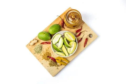 Indian mango pickle setup with green mango slices, jar and spices Stock Photos