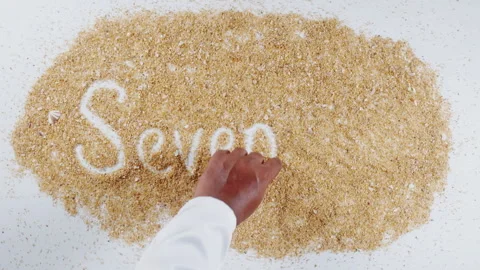 An Indian man's Hand Writes On Beach Sand words Seventeen Stock Footage 248662670