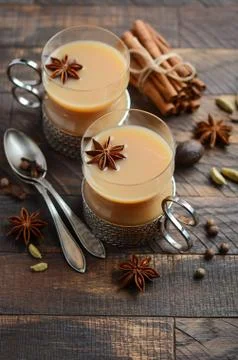 Indian masala chai tea. Spiced tea with milk in a vintage cups on the rustic woo Stock Photos