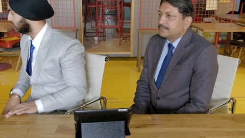 Indian men working in a co working space wearing formals look around for someone Stock Footage 102548034