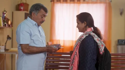 Indian middle class father giving pocket money to college going daughter at home Stock Footage 260706007