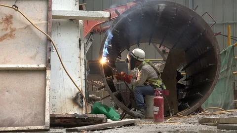 Indian migrant worker welding inside tube on construction site Singapore Video stock 78459729