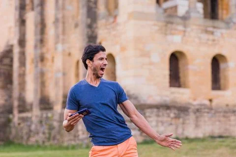 Indian model, mature man dancing Bollywood with smartphone music. Europe travel Stock Photos