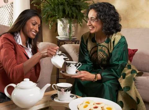 Indian mother and adult daughter having tea Stock Photos