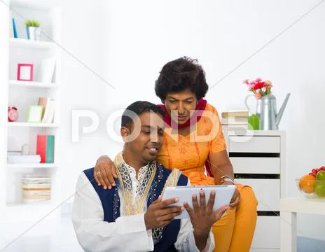 Indian mother and son enjoying surfing with tablet in the livingroom Stock Photos