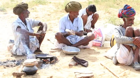 Indian nomads are preparing chapatis on fire in the desert Stock Footage 47924527