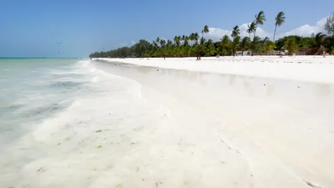 Indian ocean softly waves washing a wide white sandy beach coastline with green Video stock 248908822