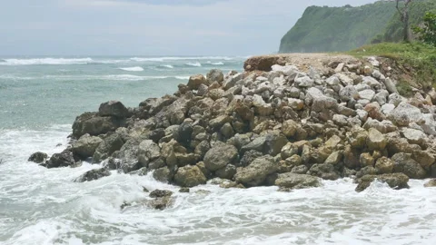 Indian Ocean waves hit rocks near Pandawa Beach and green cliff on the Stock Footage 182304461