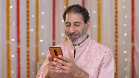 Indian old man using a mobile phone - browsing smartphone. Diwali festival ce... Stock-Footage 251728811