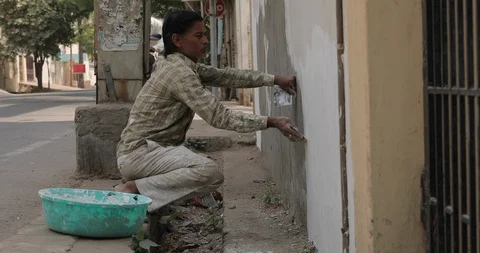 Indian Painter working on a roadside wall Video stock 111760385