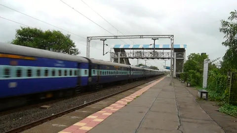Indian Passenger express train crossing scenic Umroli railway station India Stockbeeldmateriaal 306773316