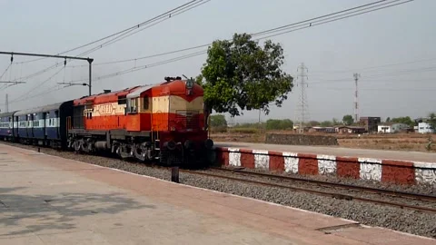 Indian Passenger express train speeding at remote railway station Mumbai India Stock Footage 132987556