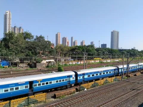 Indian Passenger mail train speeding crossing railway station near Mumbai India Foto stock