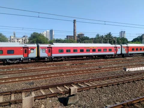 Indian Passenger mail train speeding crossing railway station near Mumbai India Foto stock