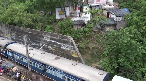An Indian passinger train passing throug a city Stock Footage 52717435