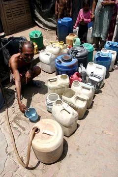Indian People Wait in Queue with Their Water Pots to Collect Drinking Water in t Foto stock