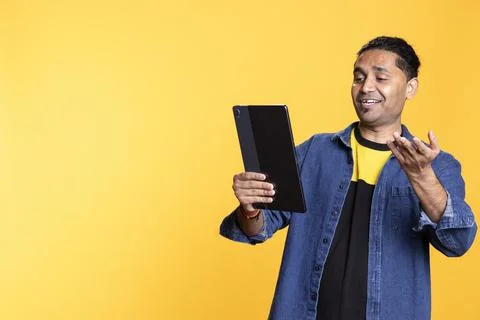 Indian person using tablet to call his friends on remote video conference Stock Photos