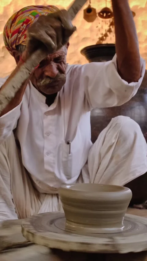 Indian potter throwing potter's wheel and shaping clay ware: pot, jar in pottery Stock Footage 344582923