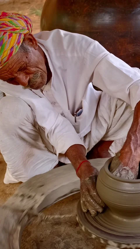 Indian potter at work throwing potter's wheel shaping clay jar in pottery Stock Footage 344582610