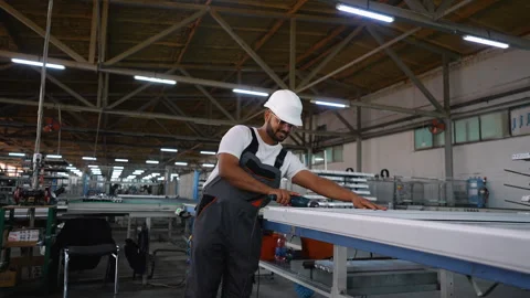 Indian PVC industry worker with drill making PVC frames for windows and doors Stock Footage 283006253