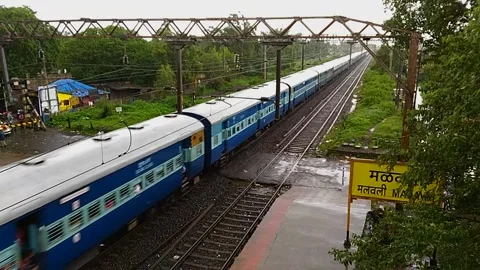 Indian Rail Passenger Train Moving speed Rainy Countryside Malavli Station India Stock Footage 137806722