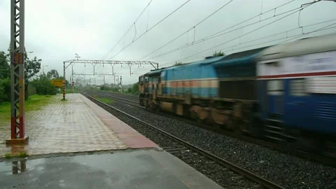 Indian Railways passenger Express Train crossing old empty Malavli station India Stock Footage 140211044
