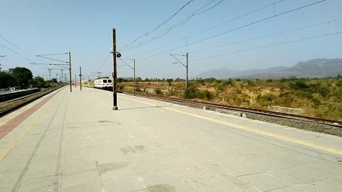 Indian Railways Red passenger train crossing speeding railway station Kelve road Video stock 127011202
