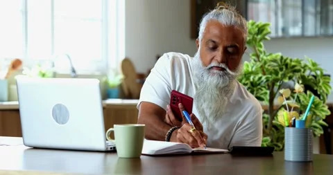 Indian Reviewing share market data at breakfast, asian mid age man trading Stock Footage 342778864