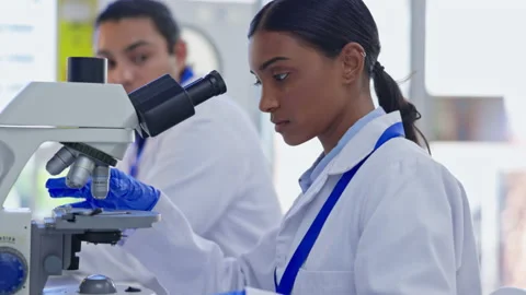 Indian scientist woman, microscope analysis or study sample for pharma product Stock Footage 237222553