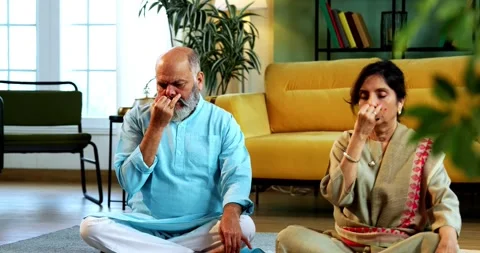 Indian senior couple doing pranayama or yoga at home in the morning Stock-Footage 342787628