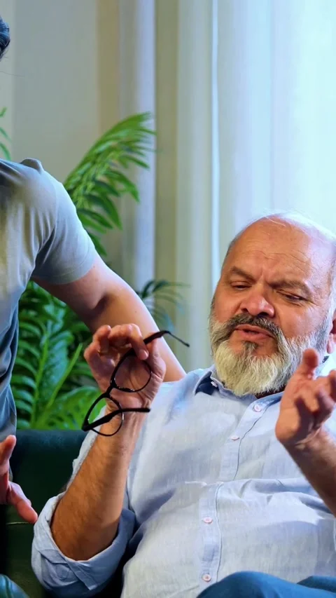 Indian senior Father Son Sharing Heartfelt Conversation At Home sitting on sofa Stock Footage 342757543