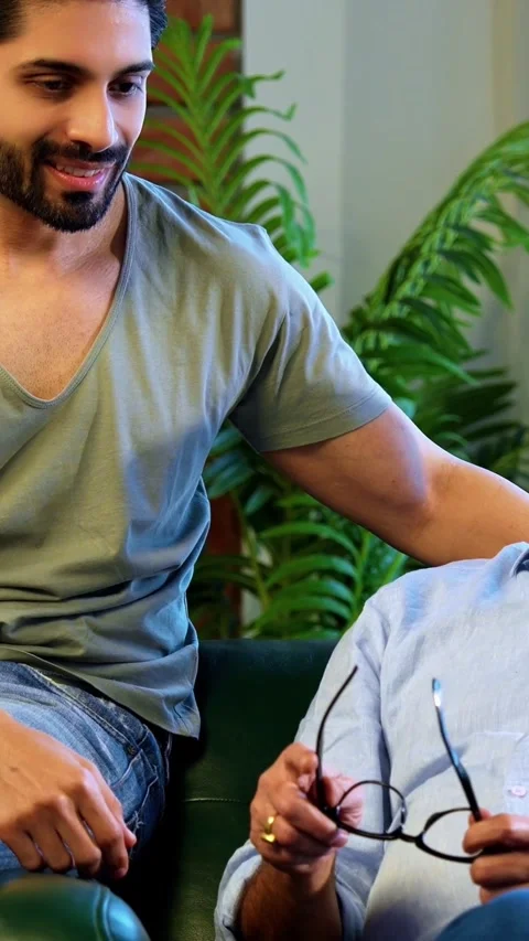 Indian senior Father Son Sharing Heartfelt Conversation At Home sitting on sofa Stock Footage 342757553