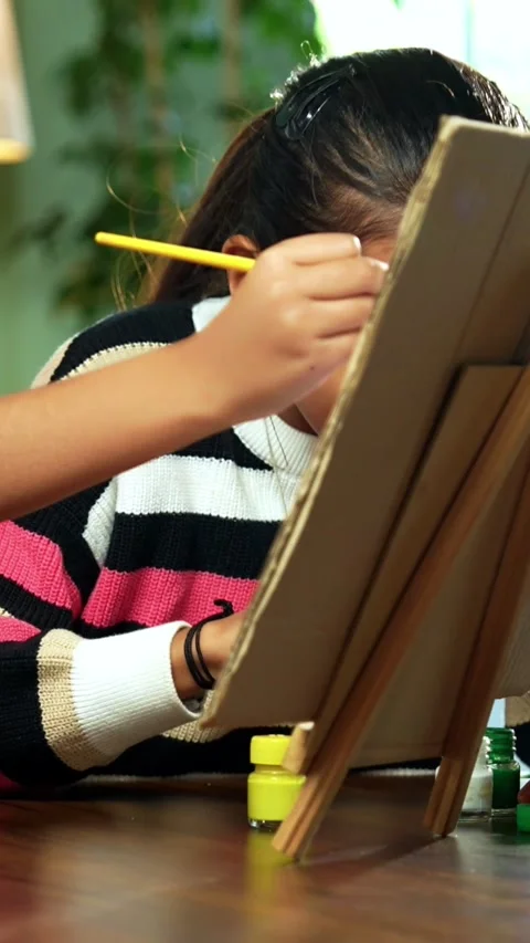 Indian siblings exploring creativity by painting on a canvas at home Stock Footage 343214420