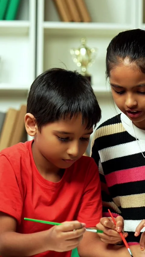 Indian siblings exploring creativity by painting on a canvas at home Stock Footage 343214448