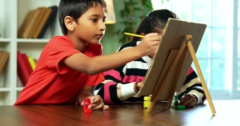 Indian siblings exploring creativity by painting on a canvas at home Stock Footage 343215718