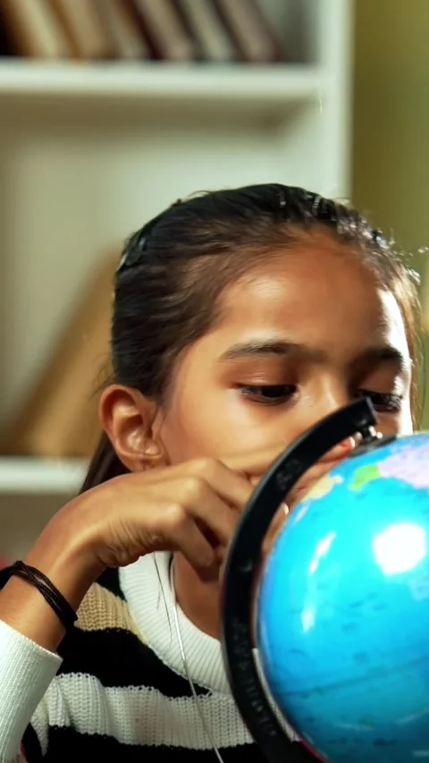 Indian siblings playing with an educational globe at home Stock Footage 343214397