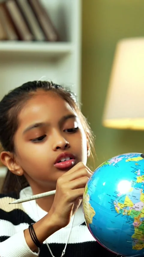 Indian siblings playing with an educational globe at home Stock Footage 343214406
