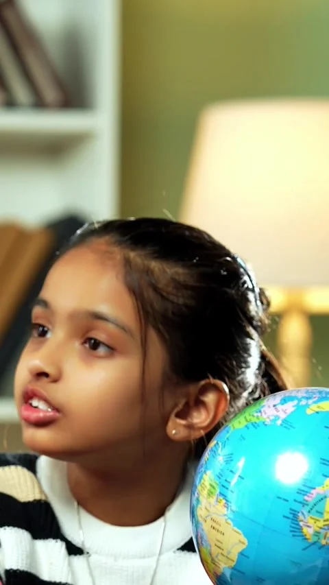 Indian siblings playing with an educational globe at home Stock Footage 343214407