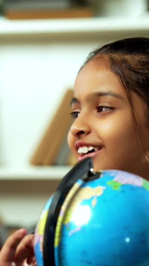 Indian siblings playing with an educational globe at home Stock Footage 343214410