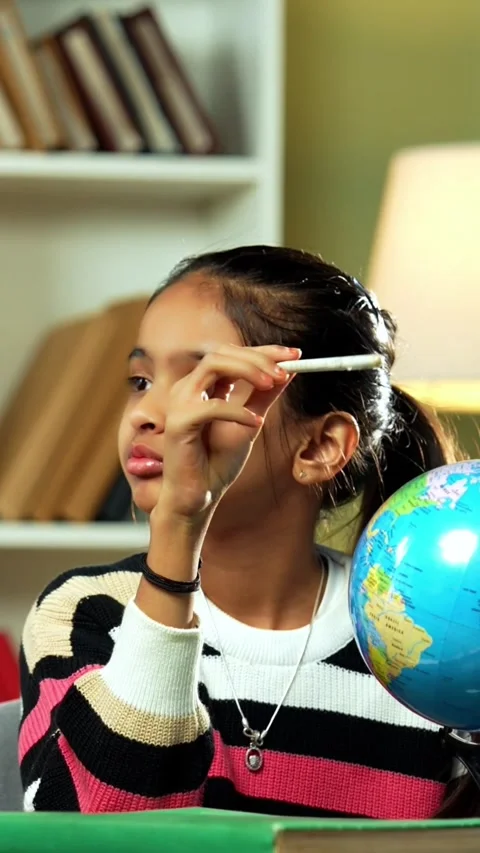Indian siblings playing with an educational globe at home Stock Footage 343214421