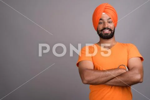 Indian Sikh man wearing turban and orange shirt Stock Photos