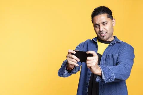 Indian single player having fun with mobile video games Stock Photos