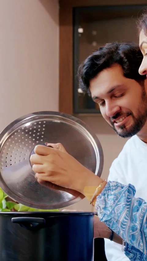 Indian smart young couple having quality time while cooking together 스톡 동영상 343416562