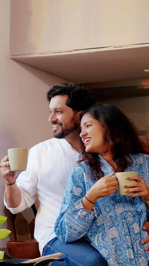 Indian smart young couple having coffee in modern kitchen Video stock 343416615