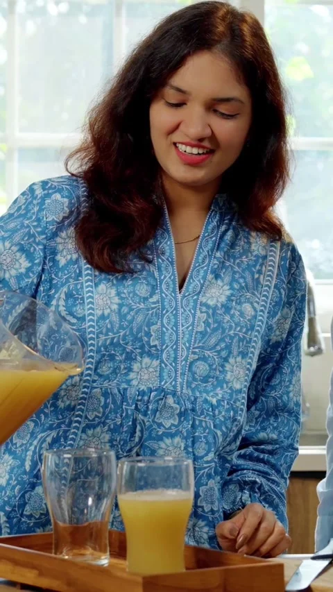 Indian smart young couple making healthy juice in kitchen Video stock 343416177