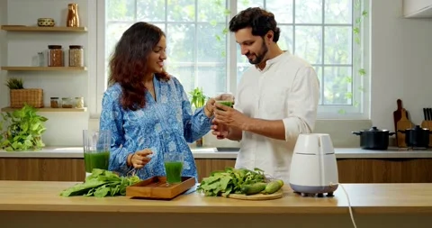 Indian smart young couple making healthy juice in kitchen Stock Footage 343490937