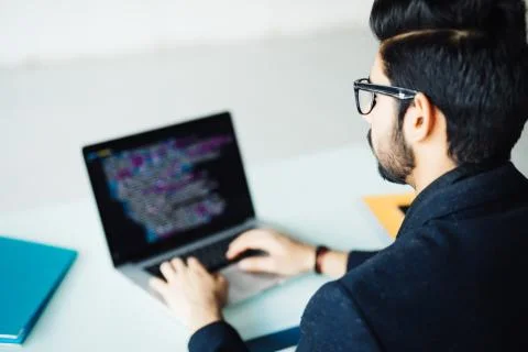 Indian software developer working on laptop at his office table Foto stock