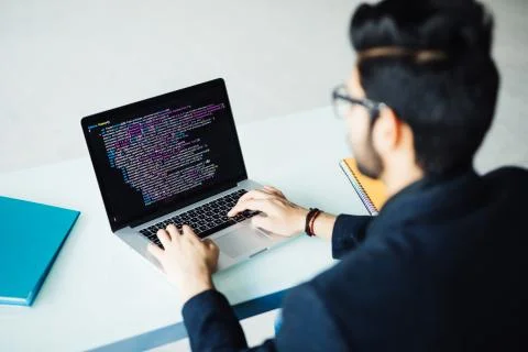 Indian software developer working on laptop at his office table Stock Photos